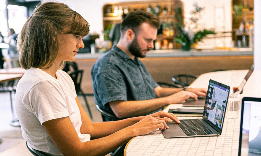 Two people using laptops
